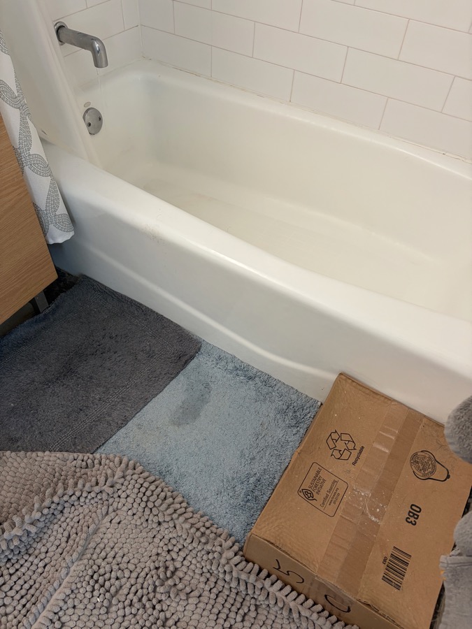 Bathtub with a cardboard box used as a step